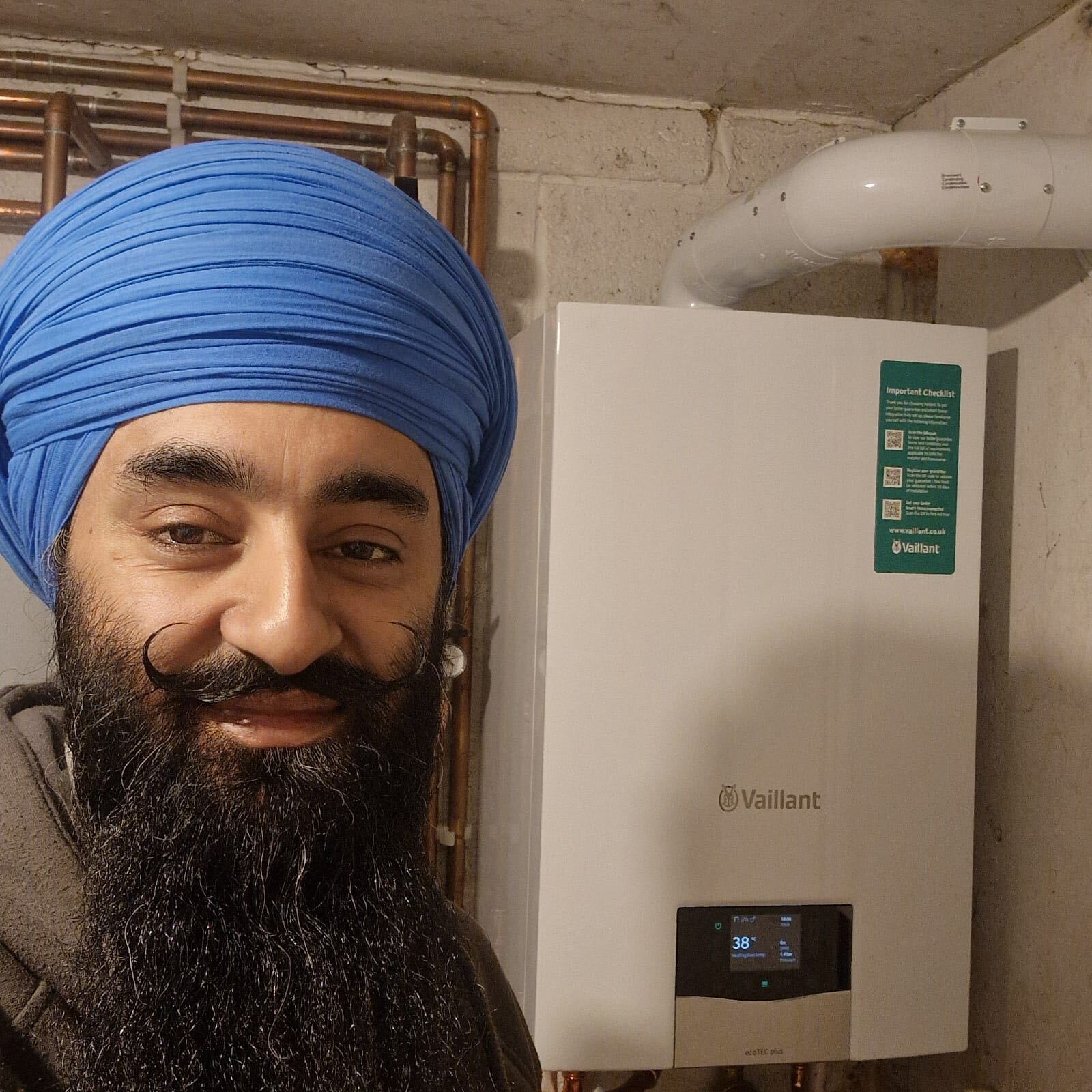 Gas Safe heating engineer from The Bearded Property Co beside a newly installed Vaillant ecoTEC plus boiler and flue, Ealing and West London, The Bearded Property Co, 020 8050 9389